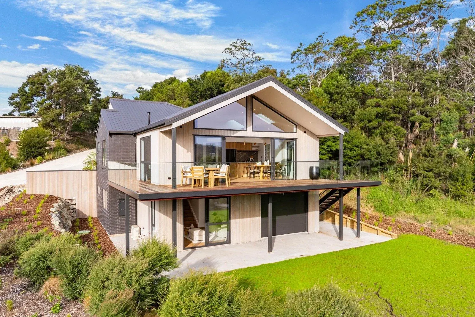 Mangawhai: frameless glass balustrades on the decks of a cedar home above native bush, by TK Glass NZ